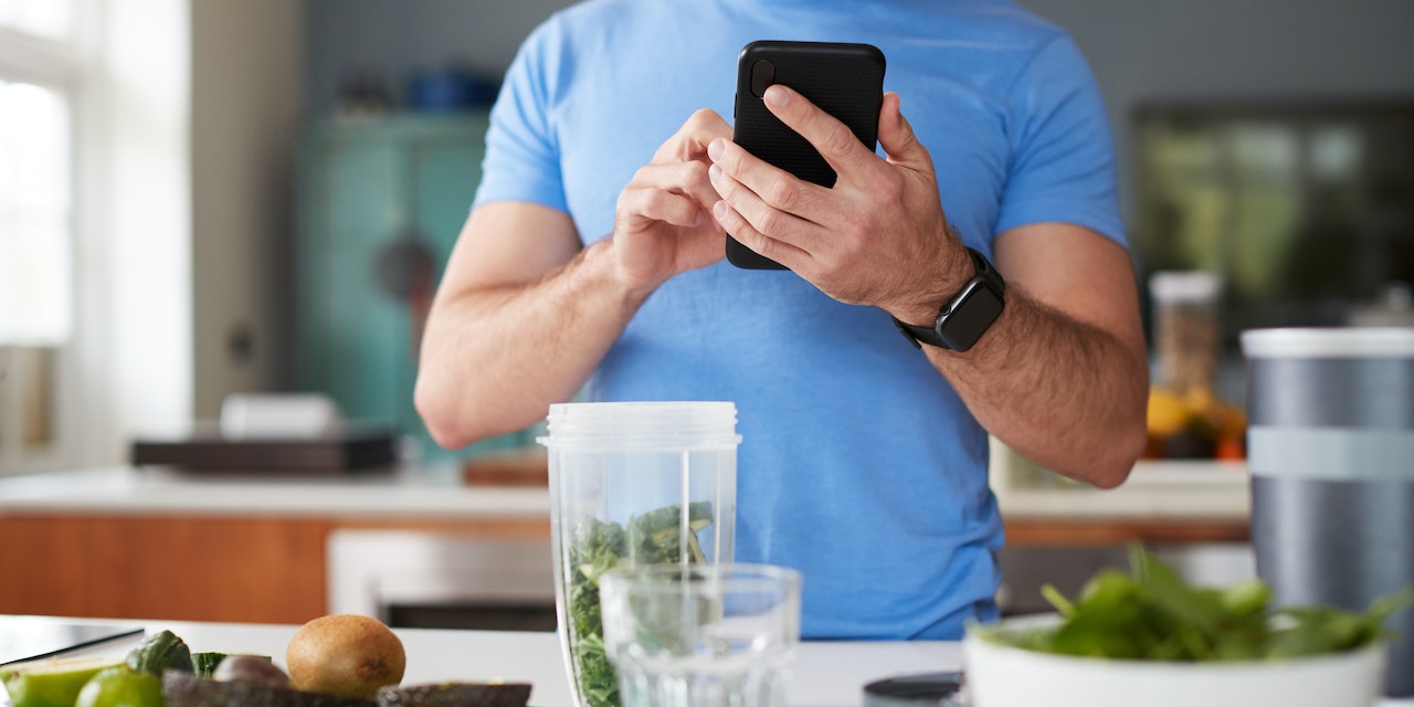 Man using Lifesum to track the macronutrients at his post workout juice