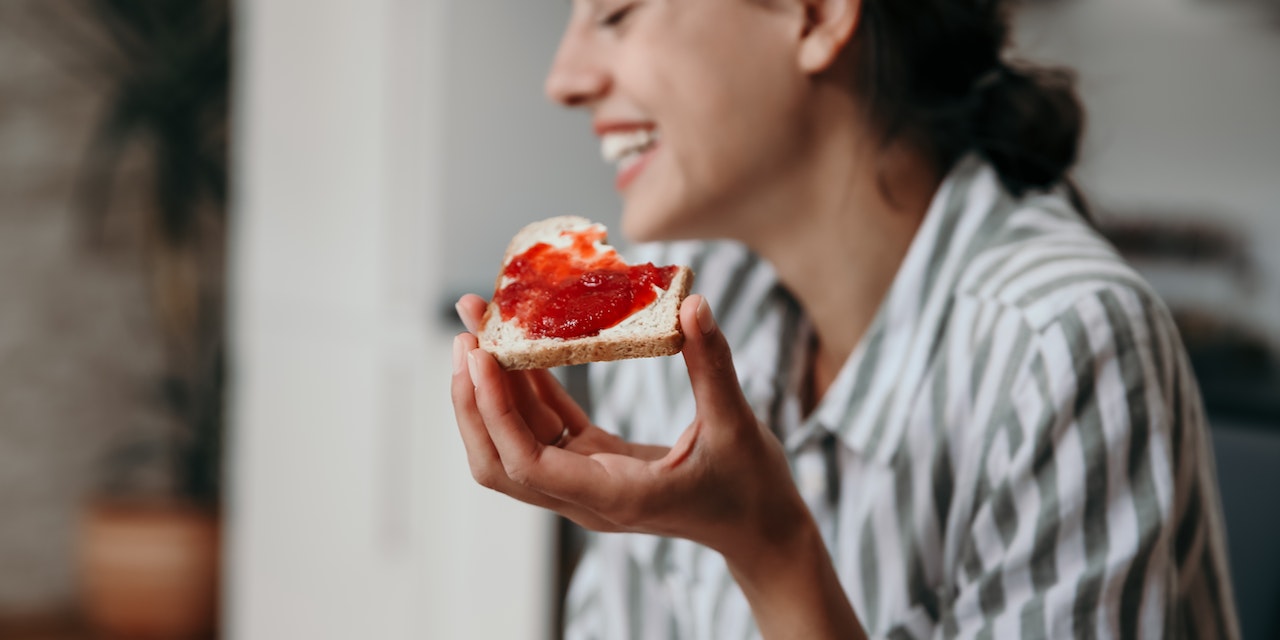 Young happy woman eating a sandwhich