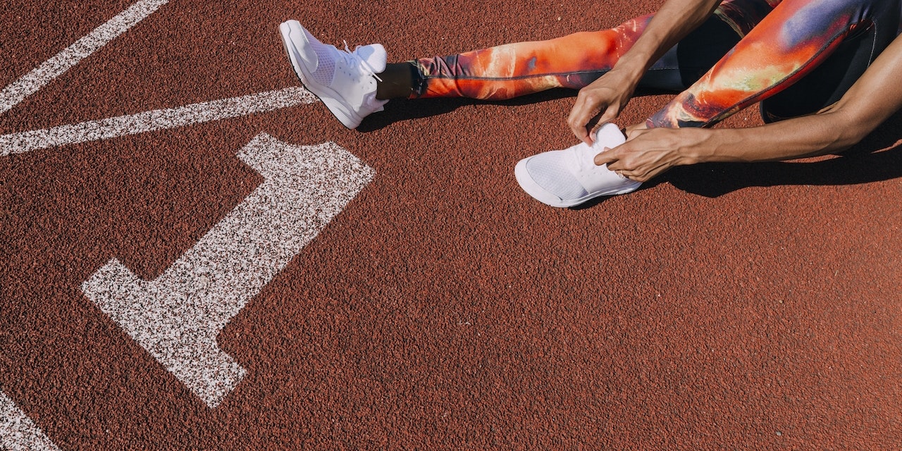 Girl tying her shoes on running track