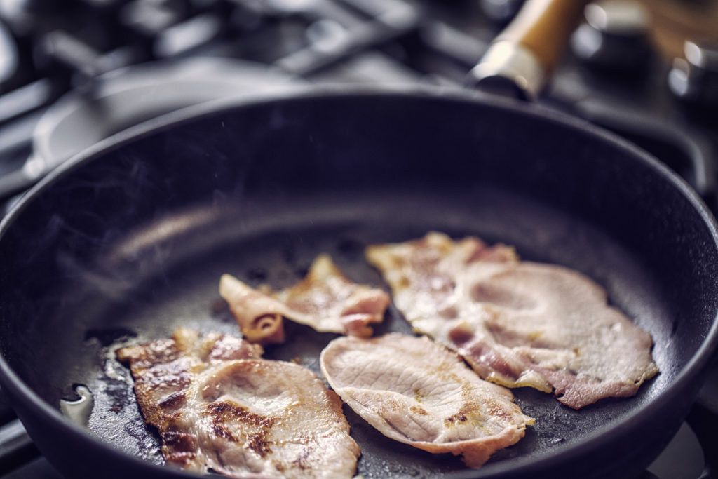 Preparing and roasting bacon in a cooking pan until it is crisp